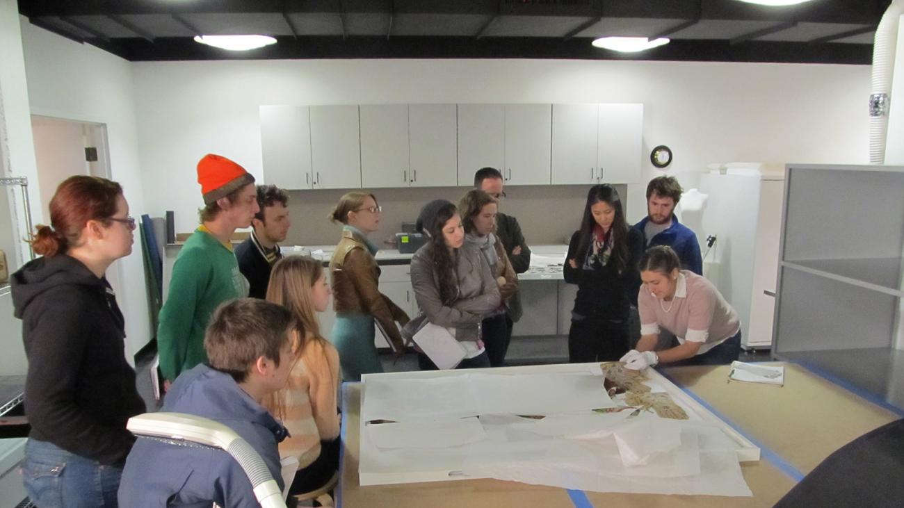 students working with conservator